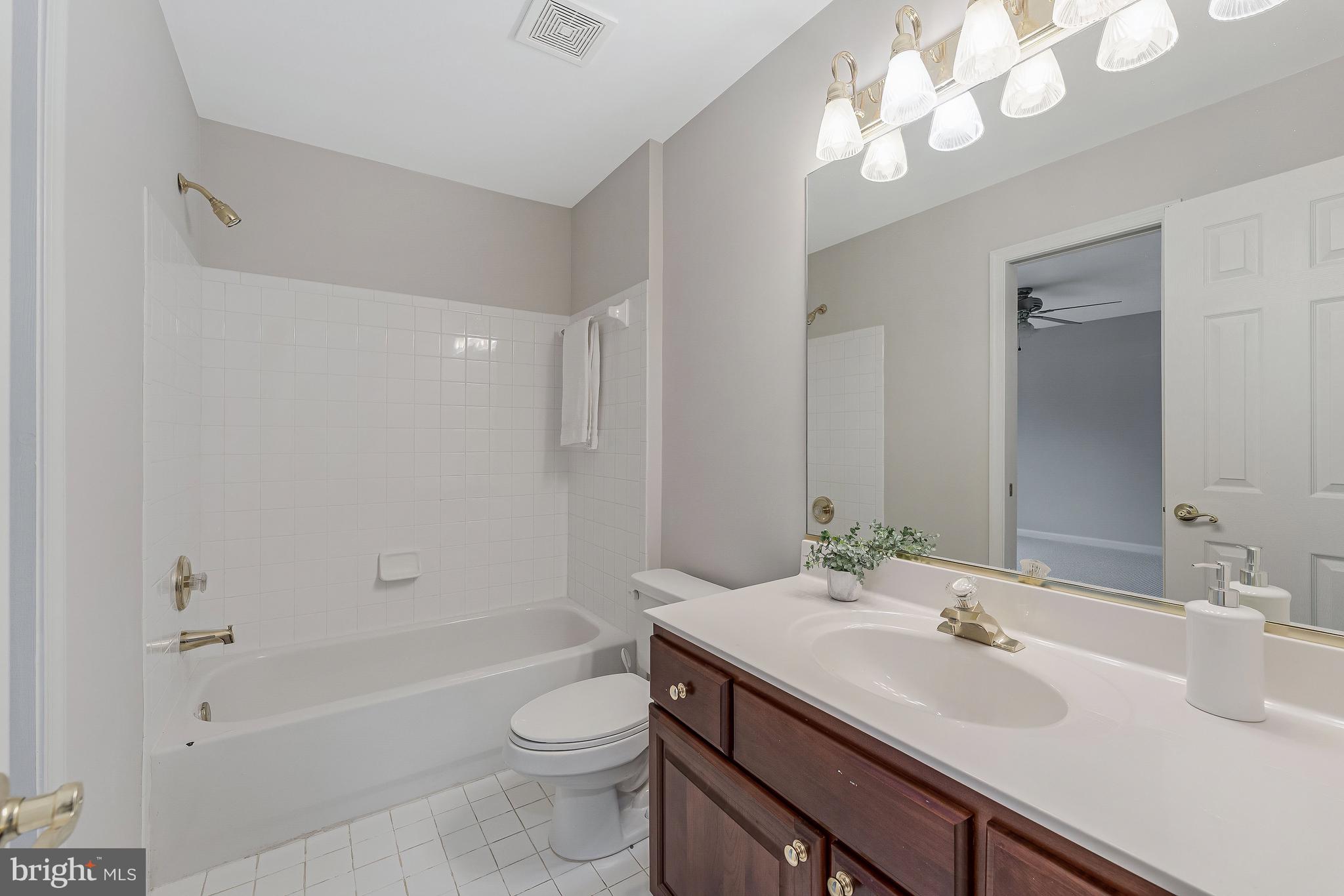 8926 Jameson Street Lorton, VA 22079 - Photo 25 of 32 a bathroom with a sink a toilet a large mirror and shower