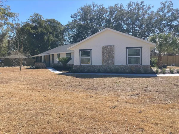 a front view of house with yard covered in snow