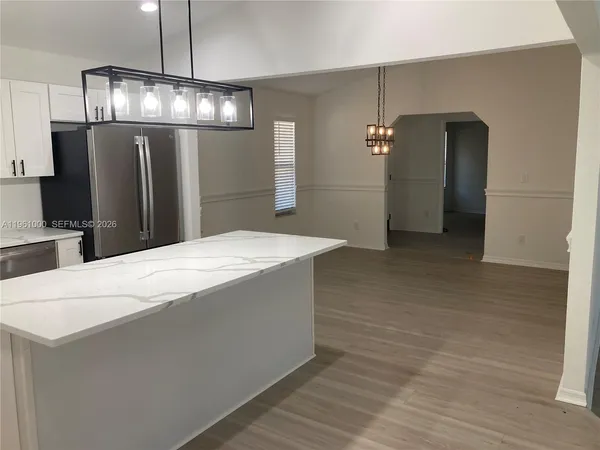 a large kitchen with stainless steel appliances a refrigerator and microwave