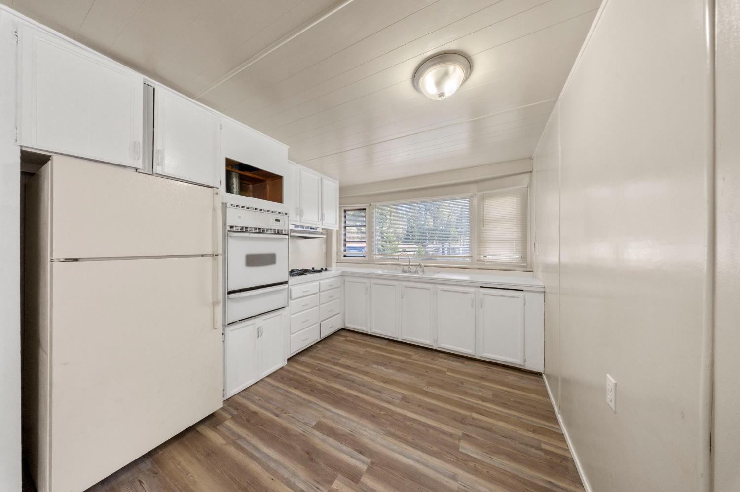 4482 Moran Road, Unit 12 Avery, CA 95224 - Photo 13 of 21 a kitchen with white cabinets and white appliances