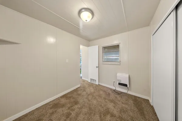 a view of a bedroom with a bed and a window