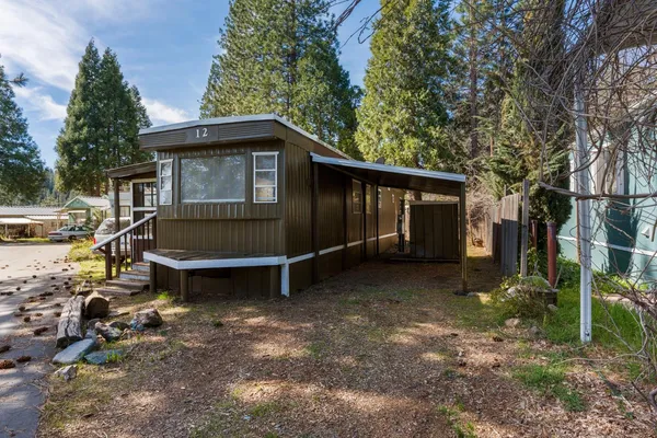 a backyard of a house with wooden fence and a tree