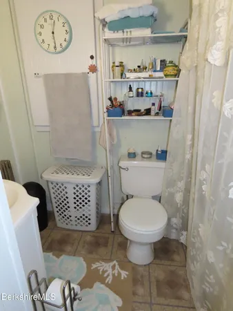 a bed sitting in a bedroom next to a window with chair