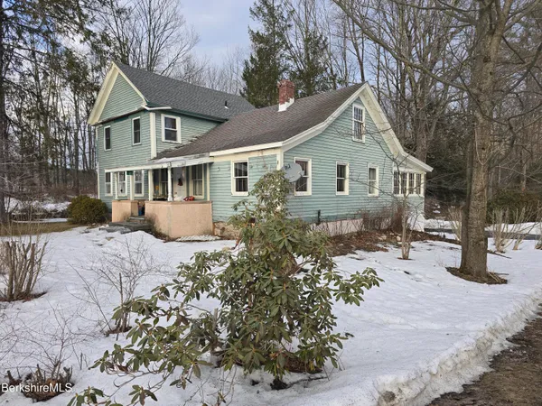 a front view of house with yard and trees around