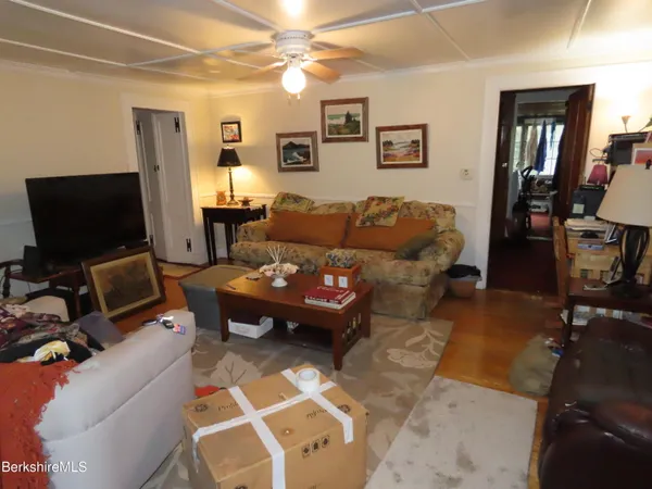 a living room with furniture a flat screen tv and a window