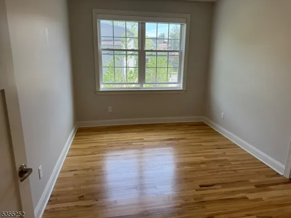 a view of a room with wooden floor and windows