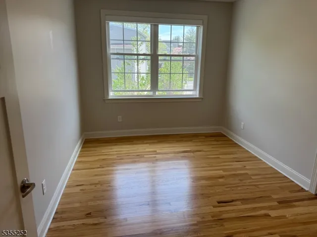 a view of a room with wooden floor and windows