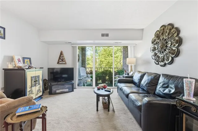 a living room with furniture a flat screen tv and a table