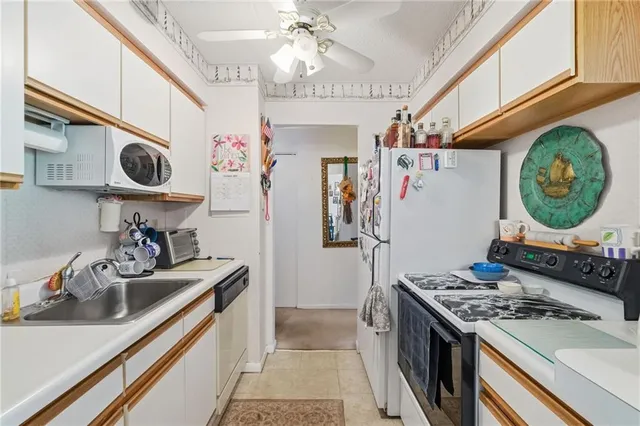 a kitchen that has a sink and a stove with wooden floor