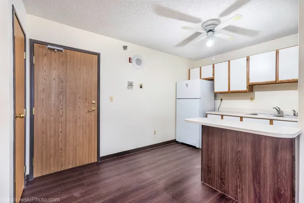 a kitchen with a wooden floor cabinets and appliances