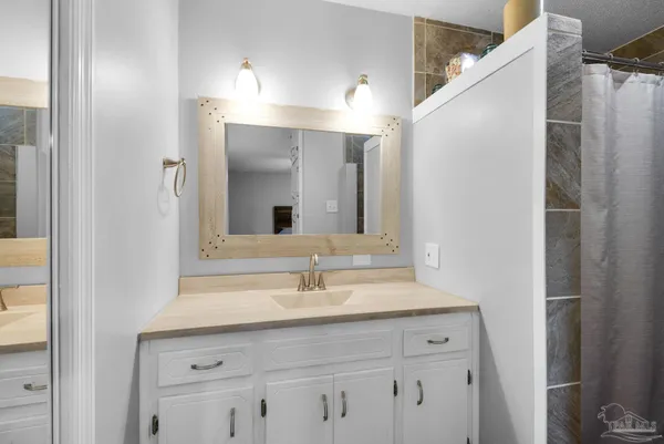 a bathroom with a sink vanity and a mirror