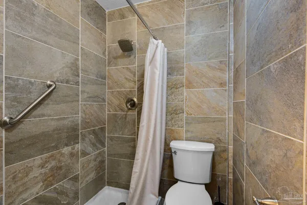 a bathroom with a toilet and a shower