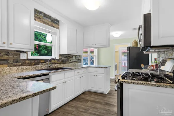 a kitchen with stainless steel appliances granite countertop a sink stove and cabinets