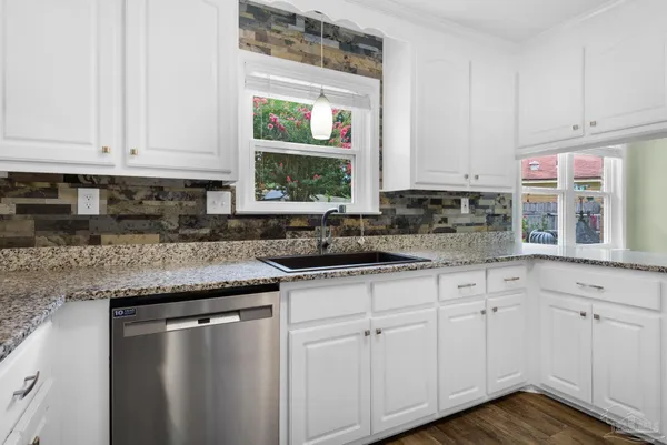 a kitchen with granite countertop white cabinets and a sink