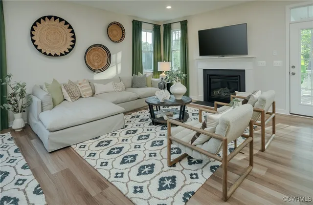 a living room with furniture a flat screen tv and a fireplace