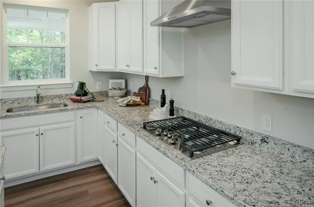a kitchen with stainless steel appliances granite countertop a sink stove and cabinets