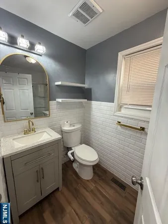 a bathroom with a toilet sink and mirror