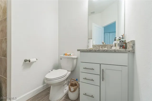 a bathroom with a granite countertop toilet sink and a mirror