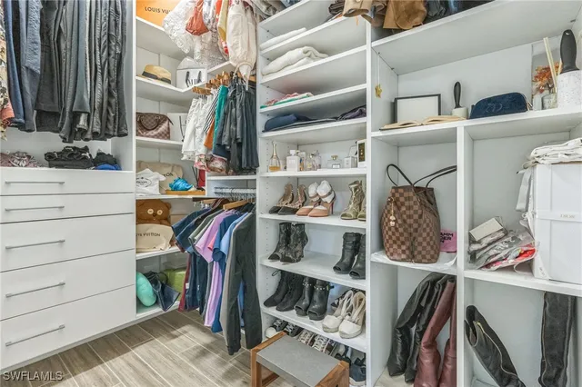 a view of walk in closet with clothes and shoes