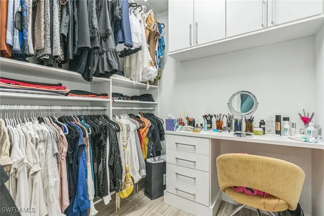 a view of walk in closet with clothes and shoes