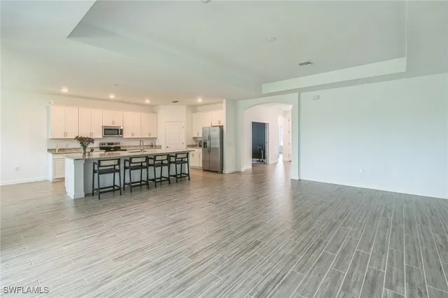 a view of kitchen with stainless steel appliances granite countertop a stove top oven a sink and a refrigerator