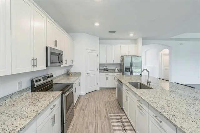 a kitchen with granite countertop a sink stove and refrigerator