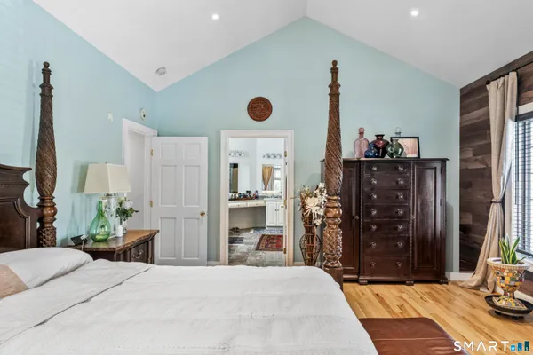 a bedroom with a bed and a flat tv screen on the dresser