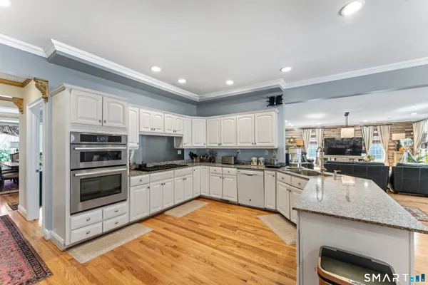 a kitchen with stainless steel appliances kitchen island granite countertop a stove and a sink