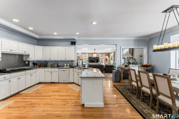 a large kitchen with stainless steel appliances and white cabinets