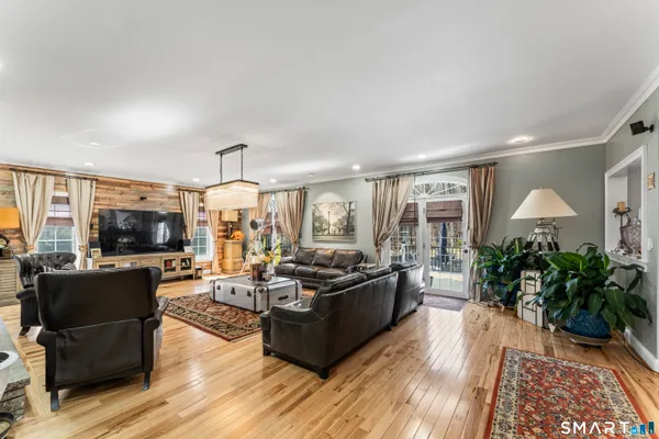 a living room with furniture flat screen tv and large window
