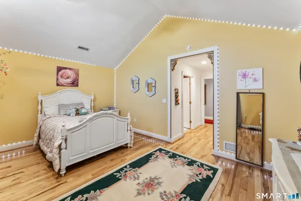 a bedroom with a bed and wooden floor