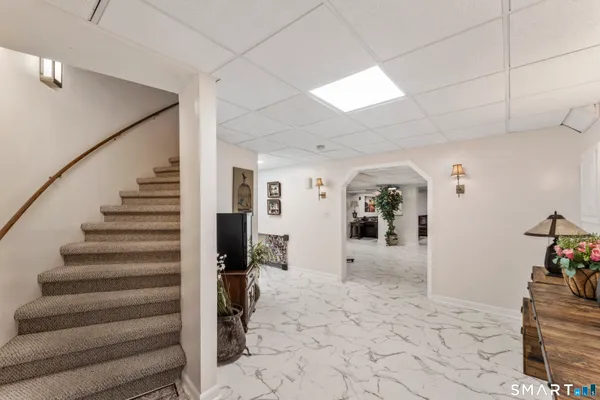 a view of a hallway to a livingroom with wooden floor and furniture