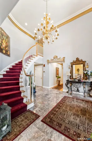 a view of a hallway with a dining table and chandelier