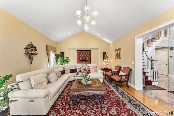 a living room with furniture a chandelier and a rug