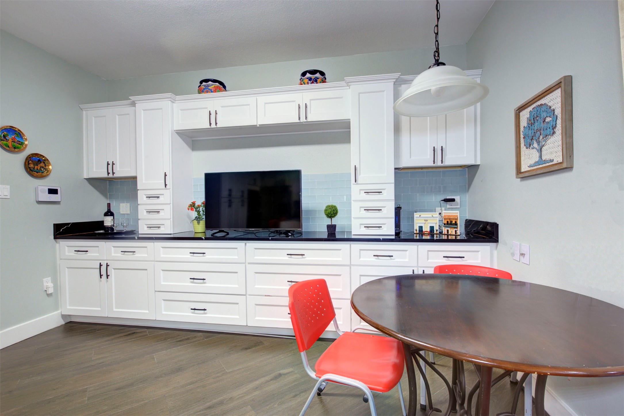 840 Threadneedle Street, Unit 208 Houston, TX 77079 - Photo 7 of 31 a kitchen with stainless steel appliances granite countertop a white cabinets a stove a sink and a dining table with wooden floor