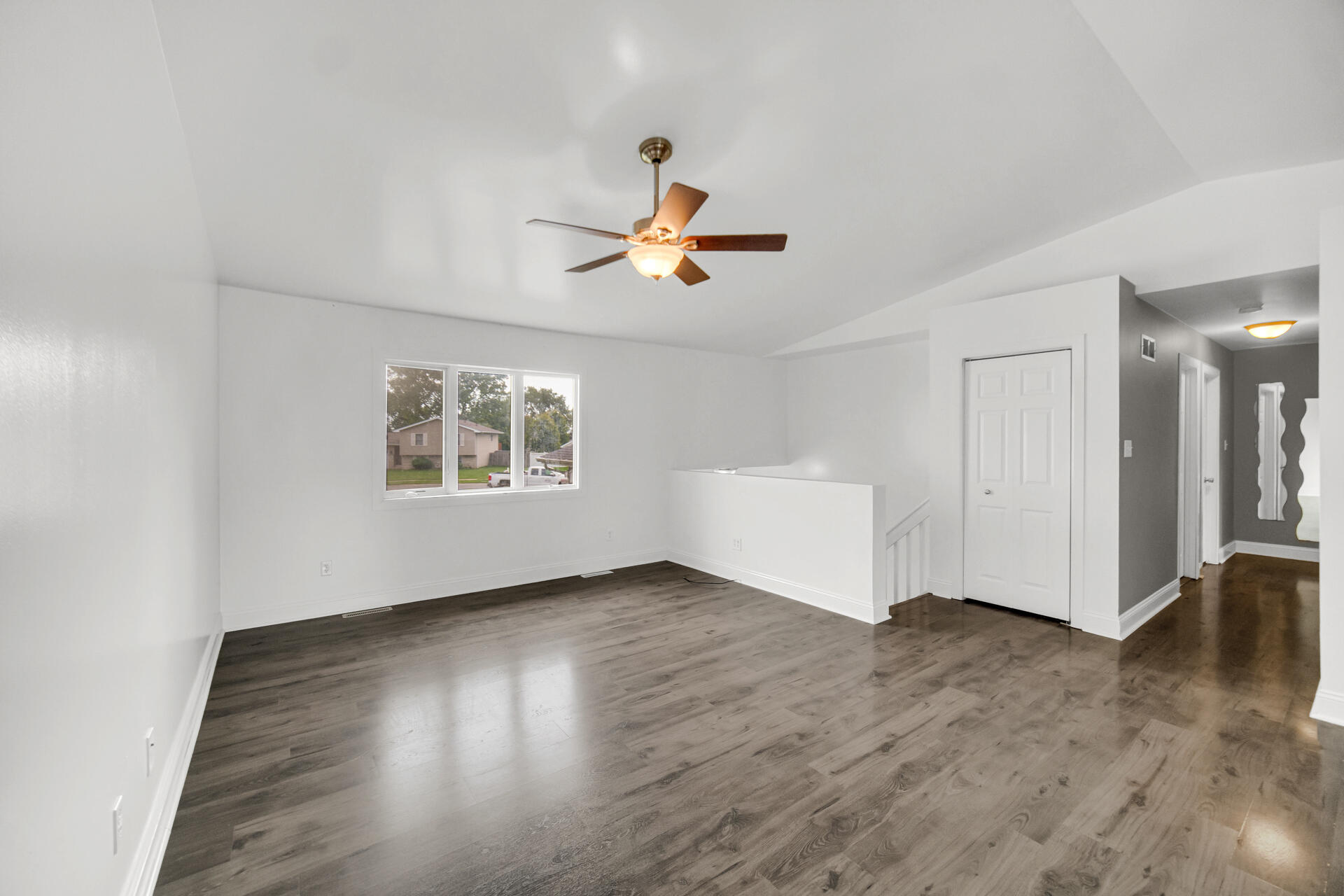 3716 Walsh Street Portage, IN 46368 - Photo 2 of 24 an empty room with wooden floor chandelier fan and windows