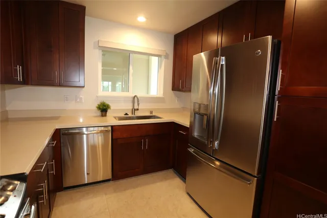 a kitchen with stainless steel appliances granite countertop a refrigerator a sink a stove and a refrigerator