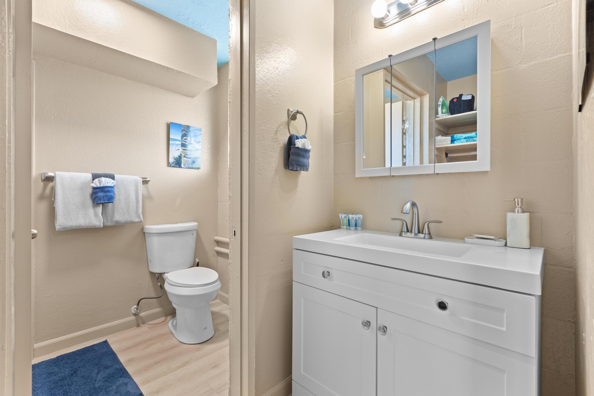 1303 Kalanianaole Street, Unit 112 Hilo, HI 96720 - Photo 16 of 27 a bathroom with a granite countertop toilet sink and mirror
