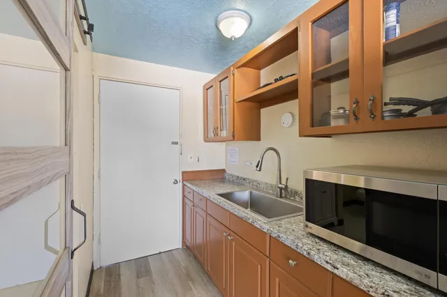 a bathroom with a granite countertop sink toilet and shower