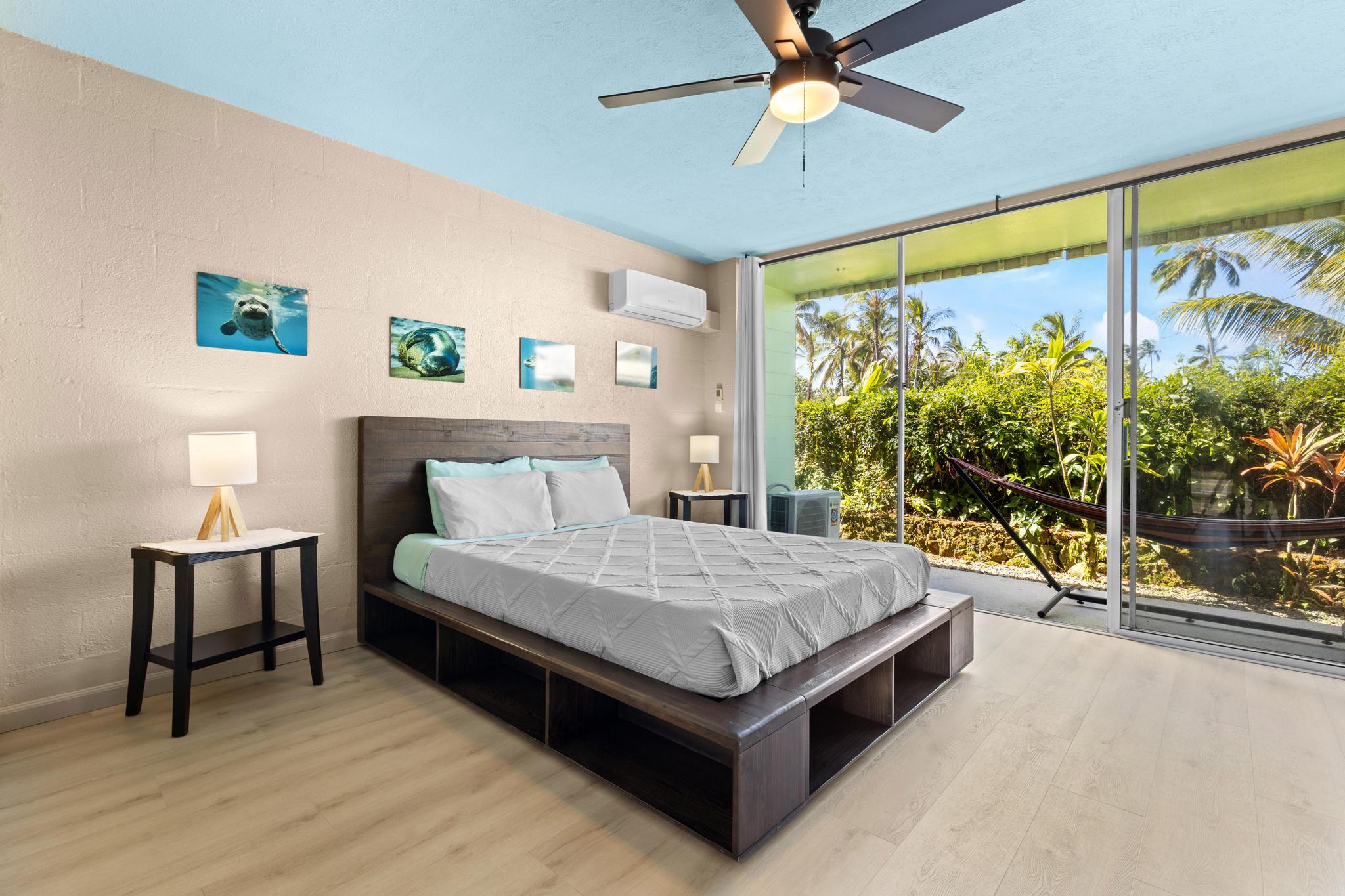 1303 Kalanianaole Street, Unit 112 Hilo, HI 96720 - Photo 3 of 27 a living room with a bed furniture and a large window