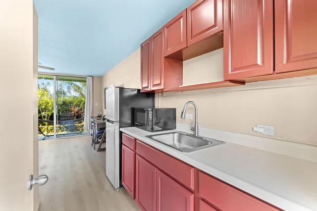 a kitchen with stainless steel appliances granite countertop a sink a stove and a wooden cabinets