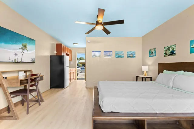 a bedroom with a bed and a refrigerator