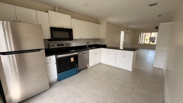 a kitchen with stainless steel appliances a refrigerator sink and microwave