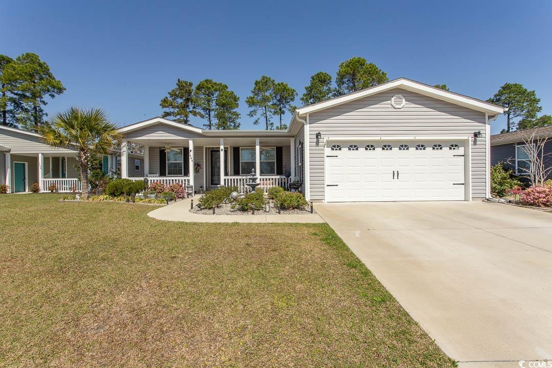 Single story home with driveway, a front lawn, cov