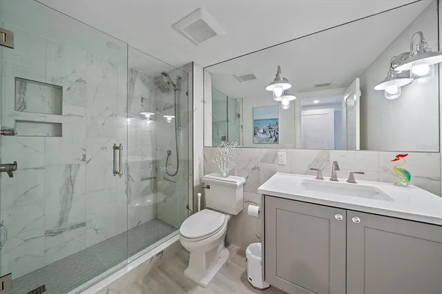 a bathroom with a sink a toilet and shower