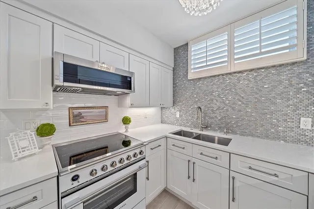 a kitchen with a sink a stove and cabinets