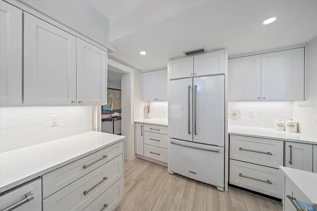 a kitchen with white cabinets and white appliances