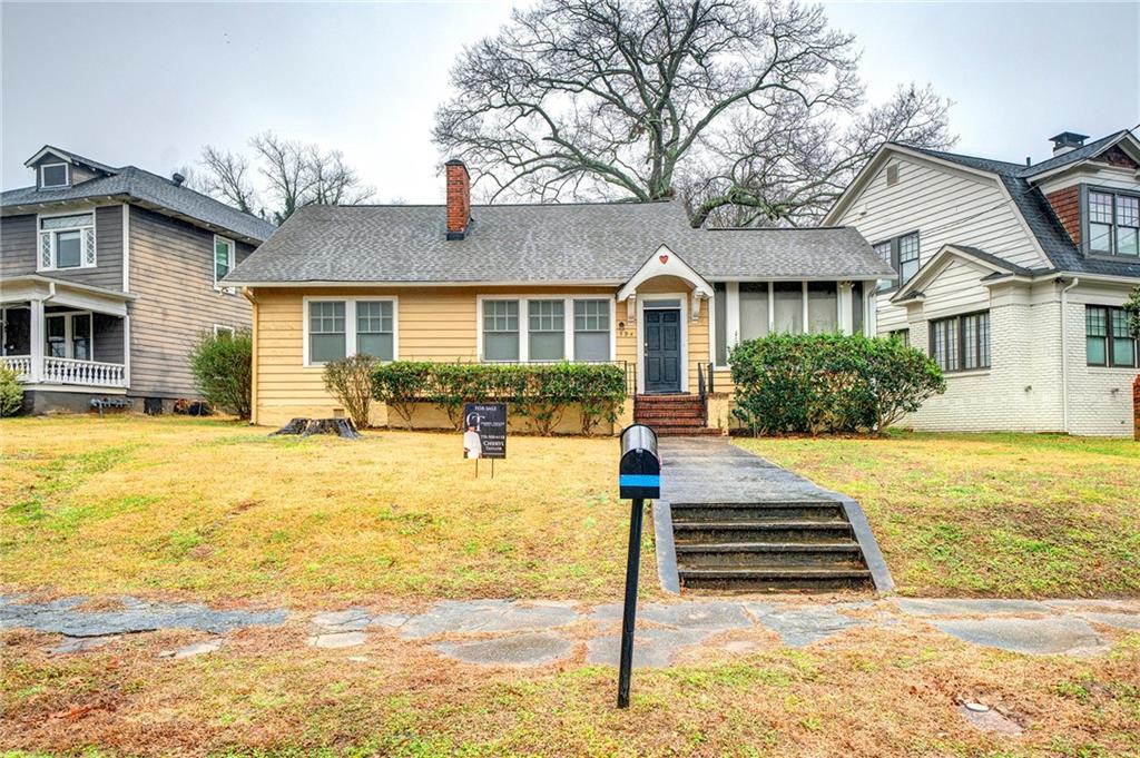 a front view of house with yard and trees around