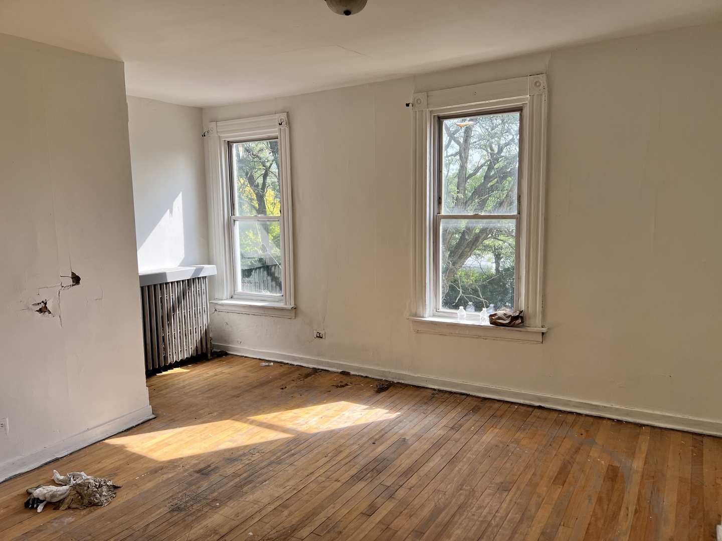 10614 South Langley Avenue, Unit 10614 Chicago, IL 60628 - Photo 2 of 11 an empty room with wooden floor and windows
