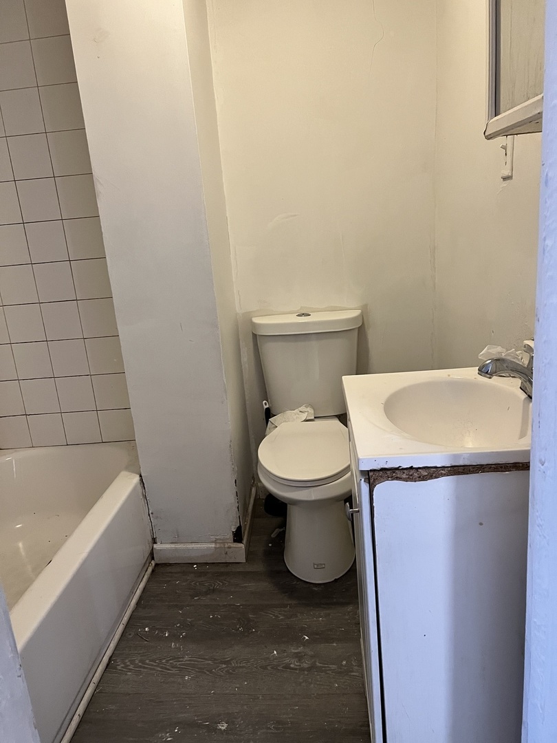 10614 South Langley Avenue, Unit 10614 Chicago, IL 60628 - Photo 4 of 11 a white toilet sitting next to a bath tub